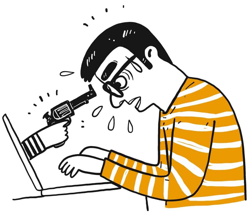 Gun pointing at man typing on computer